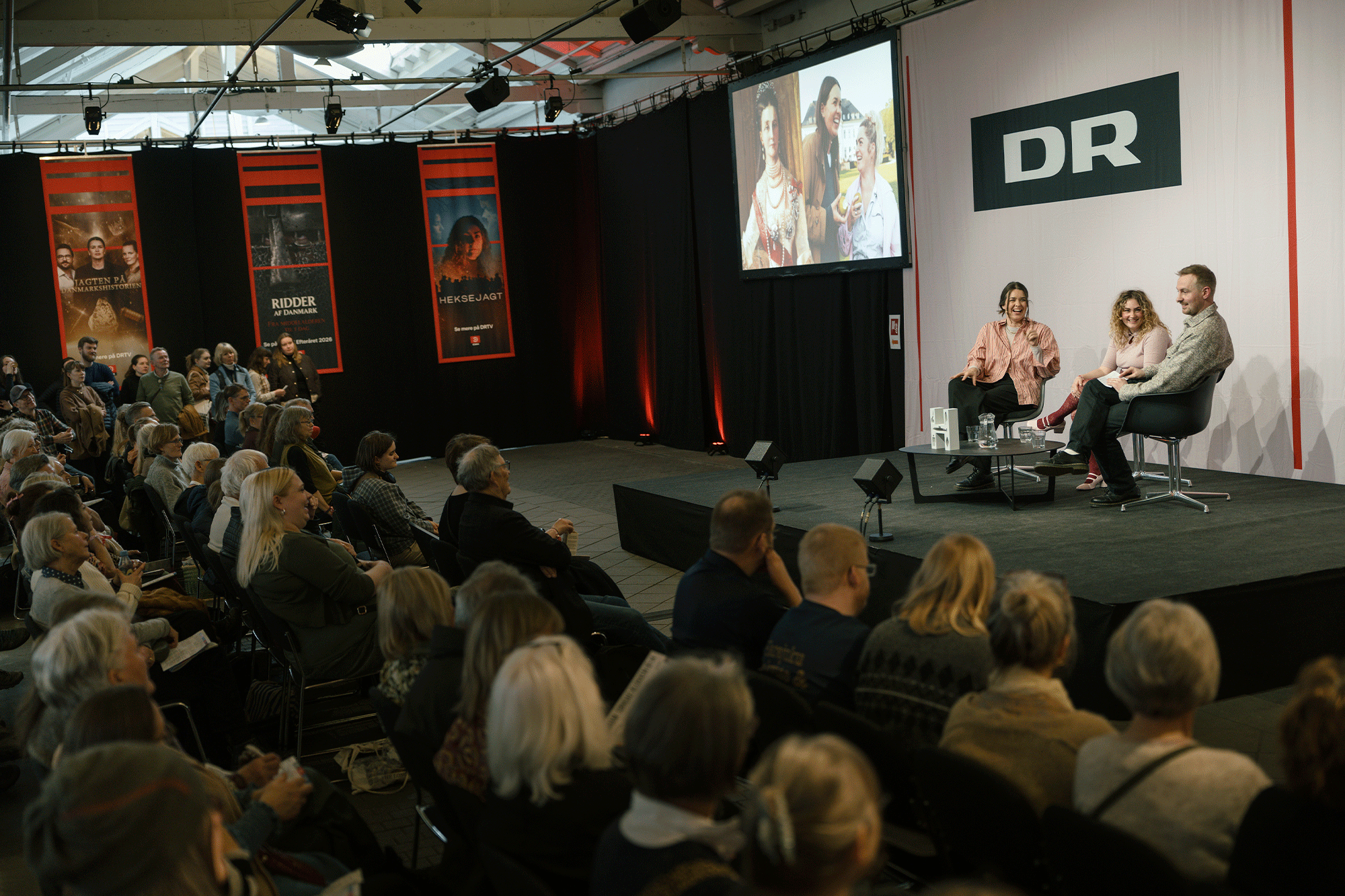 Historikerne og DR-værterne Cecilie Nielsen og Emma Paaske taler med historiker og konferencier på DR-scenen Peter Ørbæk Larsen om, hvordan de danske dronninger gennem tiden har haft masser af indflydelse og har været afgørende for det Danmark, vi kender i dag. Foto: Martin Dam Kristensen.